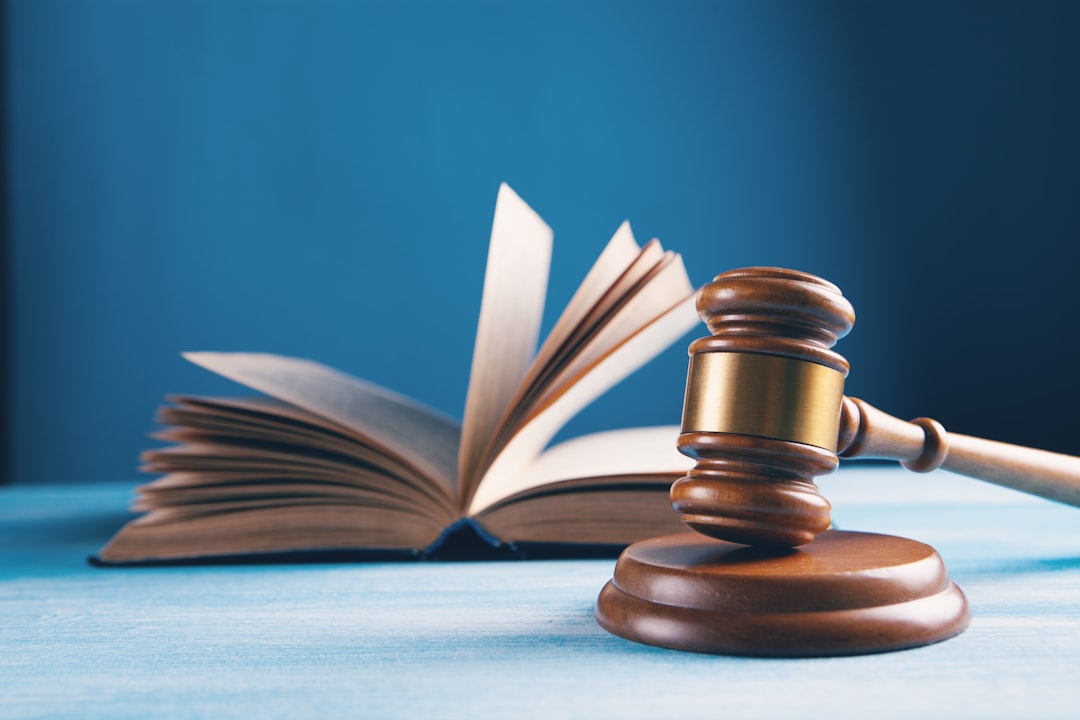 Wooden gavel and an open law book on a blue background